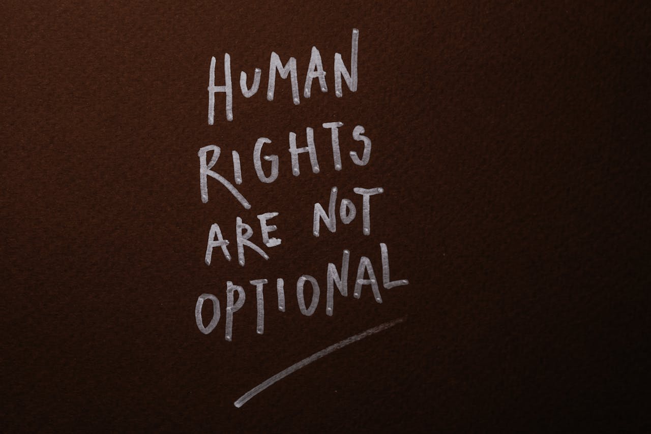 Home Handwritten message advocating for human rights on a rich brown background.